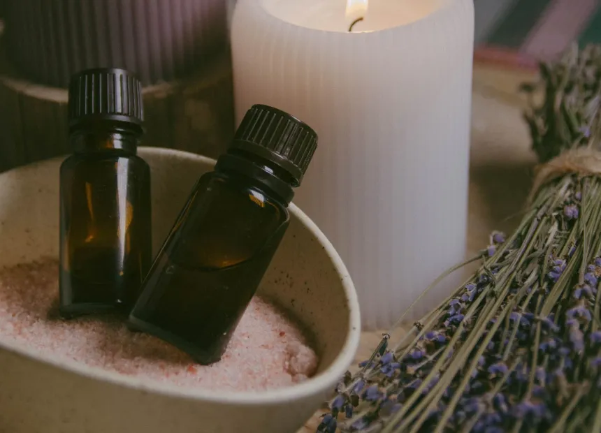 Aromatické oleje, svíčka a levandule připravené k masáži